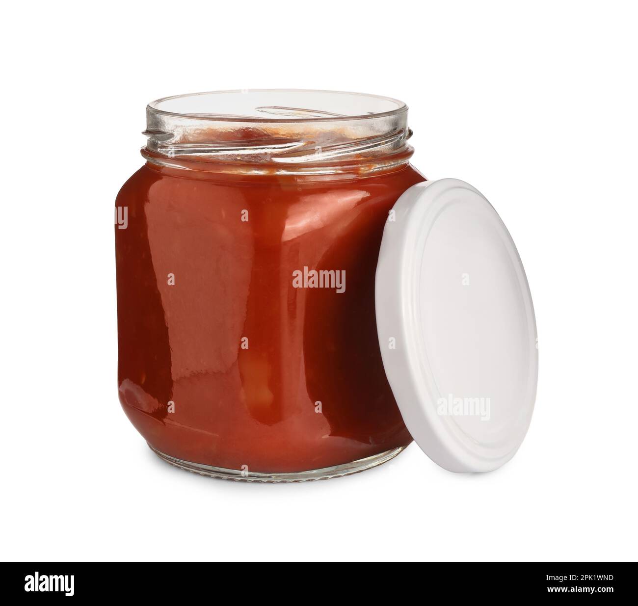 Glass jar of delicious canned lecho and lid on white background Stock