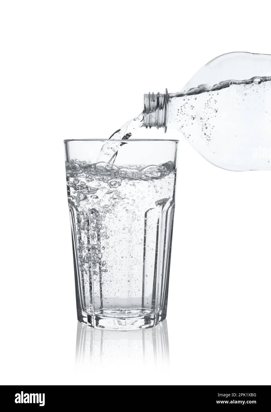 Pouring soda water from bottle into glass on white background Stock