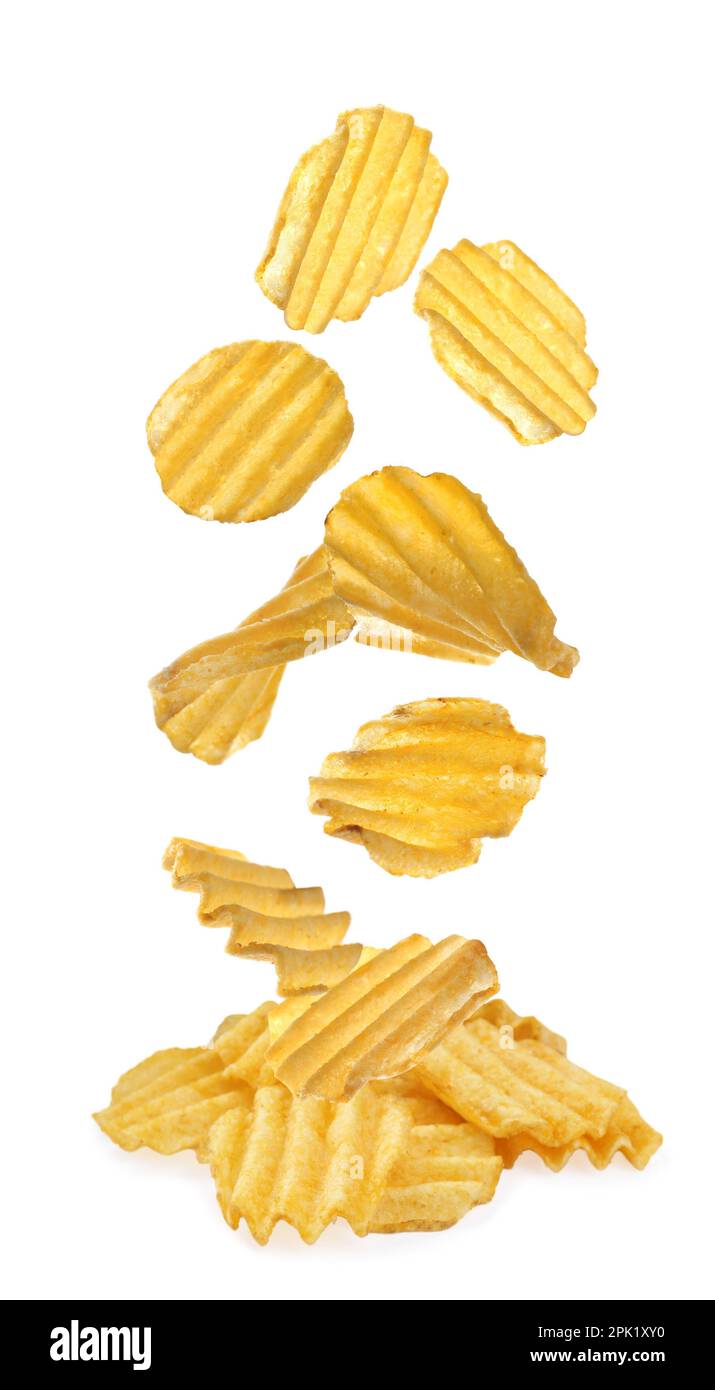 Ridged crispy potato chips falling into heap on white background Stock Photo