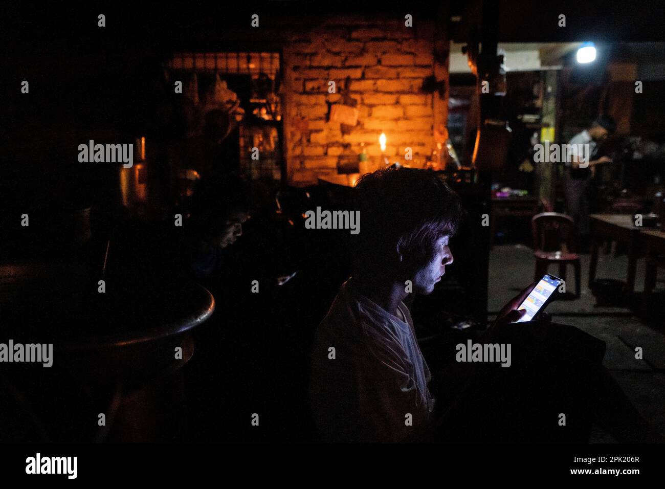 During an electricity blackout, people use cellphones and drink tea by