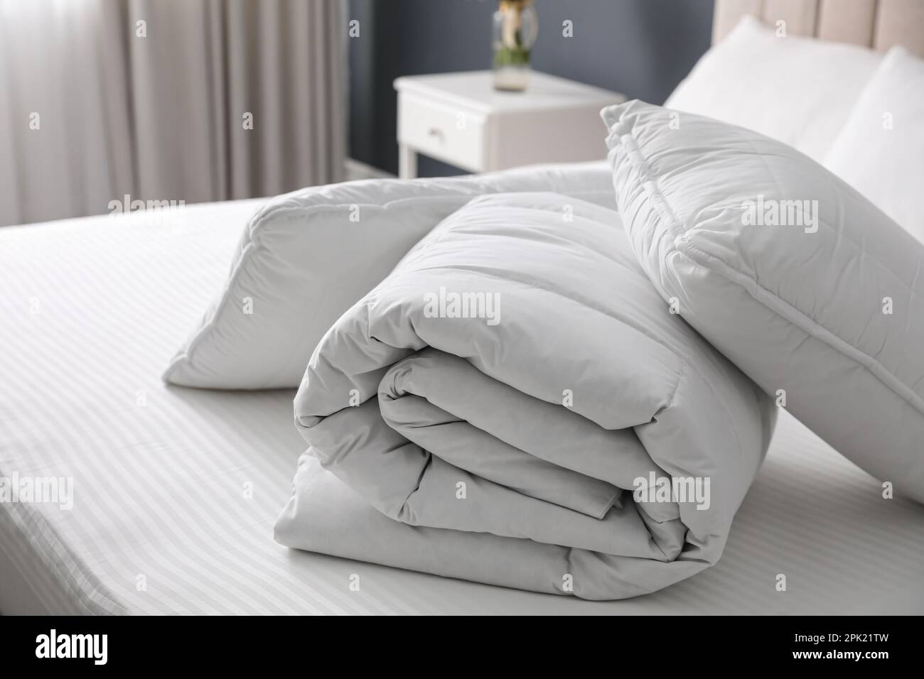 Soft folded blanket and pillows on bed indoors Stock Photo