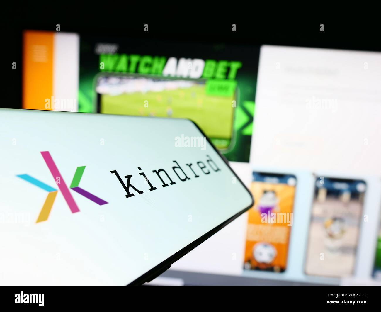 Cellphone with logo of online gambling company Kindred Group plc on screen in front of business website. Focus on center-left of phone display. Stock Photo
