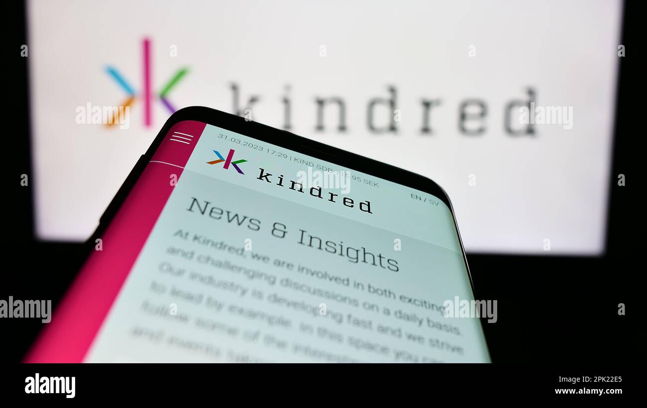 Mobile phone with webpage of online gambling company Kindred Group plc on screen in front of business logo. Focus on top-left of phone display. Stock Photo