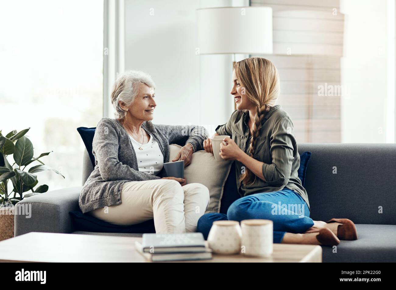 We love sharing stories. a senior woman and her adult daughter sitting ...