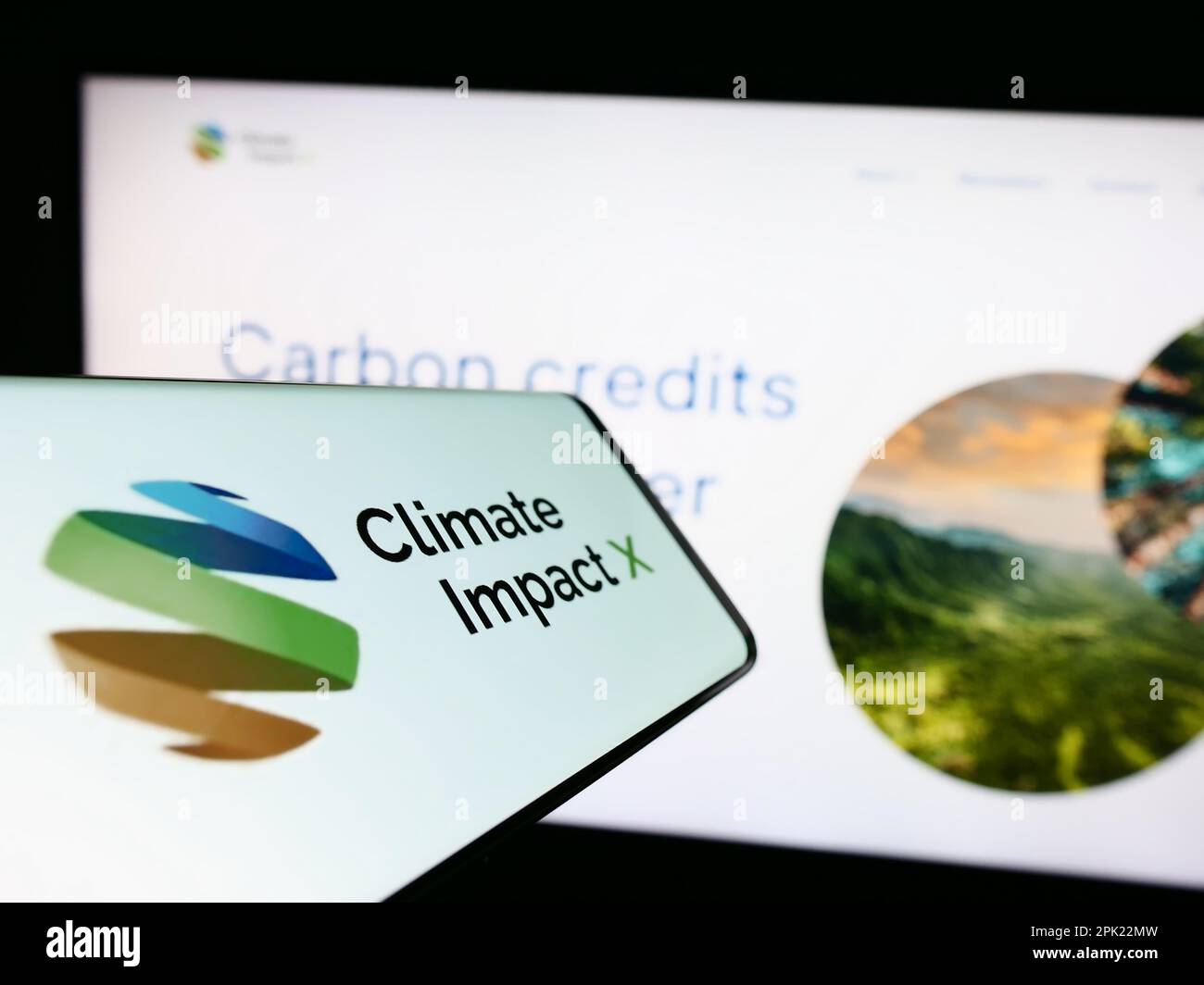 Smartphone with website of carbon exchange Climate Impact X (CIX) on screen in front of business business logo. Focus on center of phone display. Stock Photo