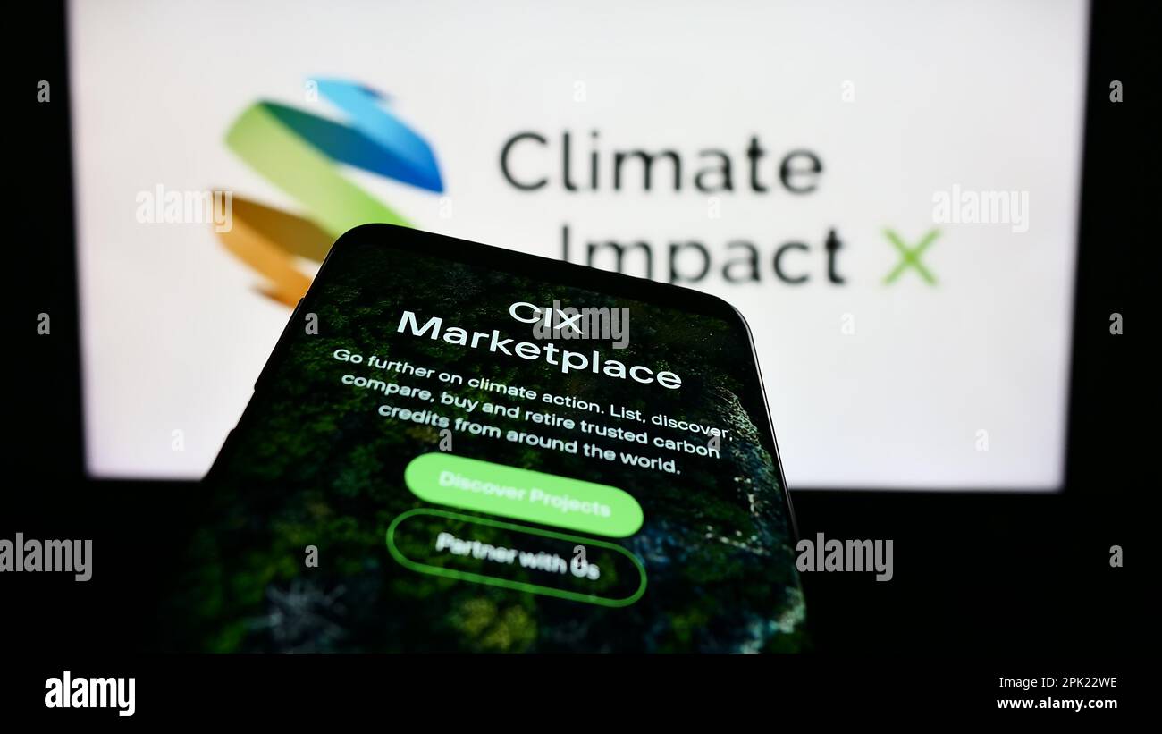 Mobile phone with webpage of carbon exchange Climate Impact X (CIX) on screen in front of business logo. Focus on top-left of phone display. Stock Photo