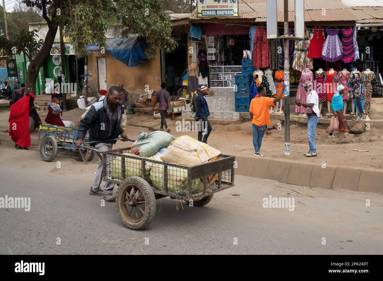 Arusha, Tanzania - October 17th, 2022: A porter pushing a cart full of parcels in the main street of Arusha, Tanzania. Stock Photo