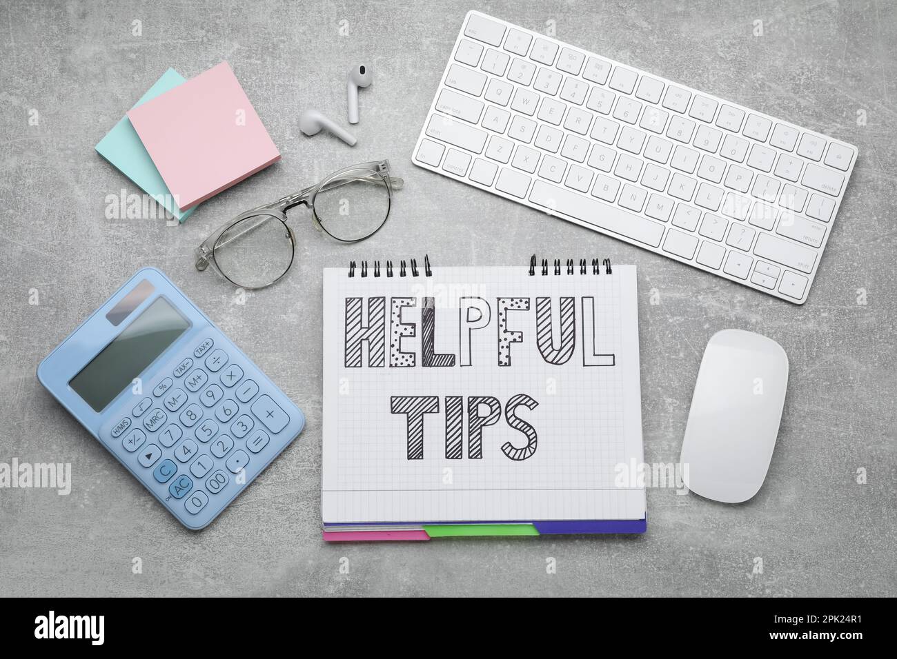 Flat lay composition with text Helpful Tips in notebook on grey table Stock Photo