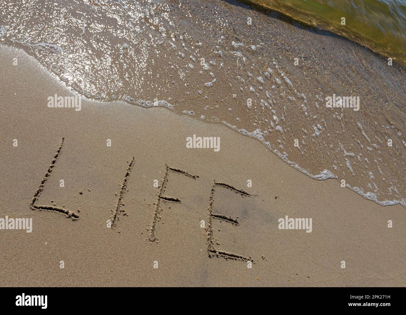 The inscription Life on the sand of the seashore. The concept of lifestyle, thirst for life, happiness, freedom, enjoyment of life. Stock Photo