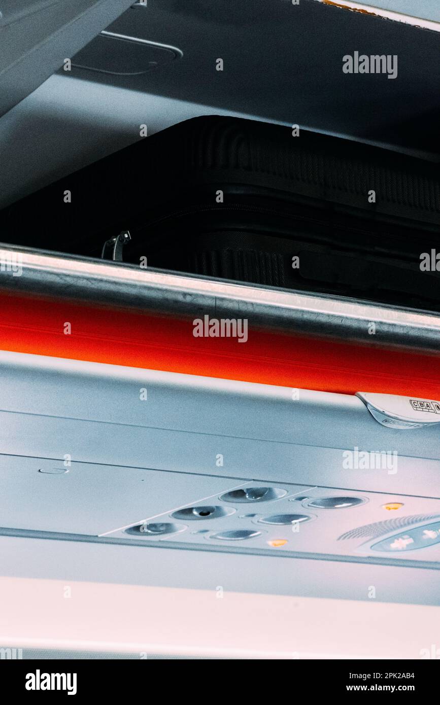 Carryon luggage in overhead storage compartment on commercial airplane