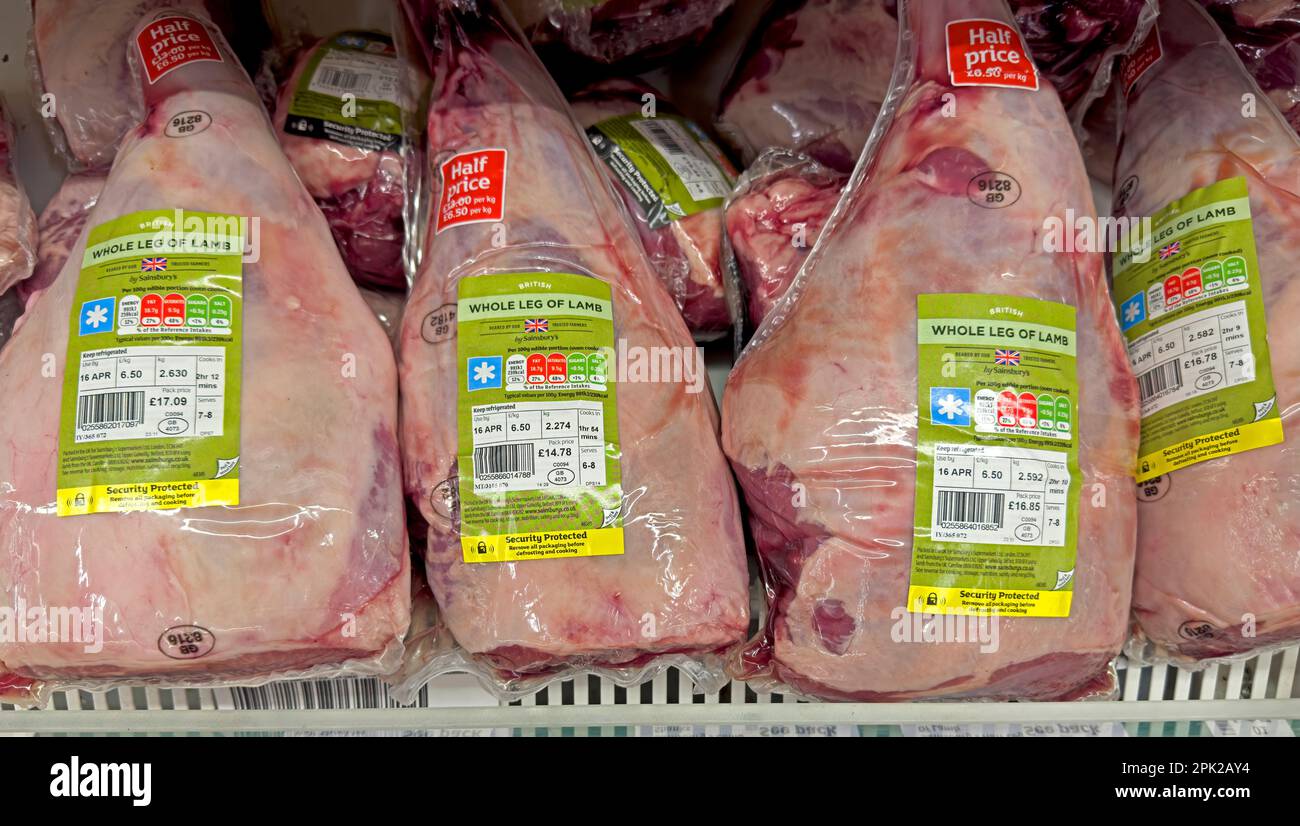 Legs of lamb on offer, meat refrigerator at Sainsburys supermarket - half price at £6.50 per KG -Increasing unaffordability of meat due to inflation Stock Photo