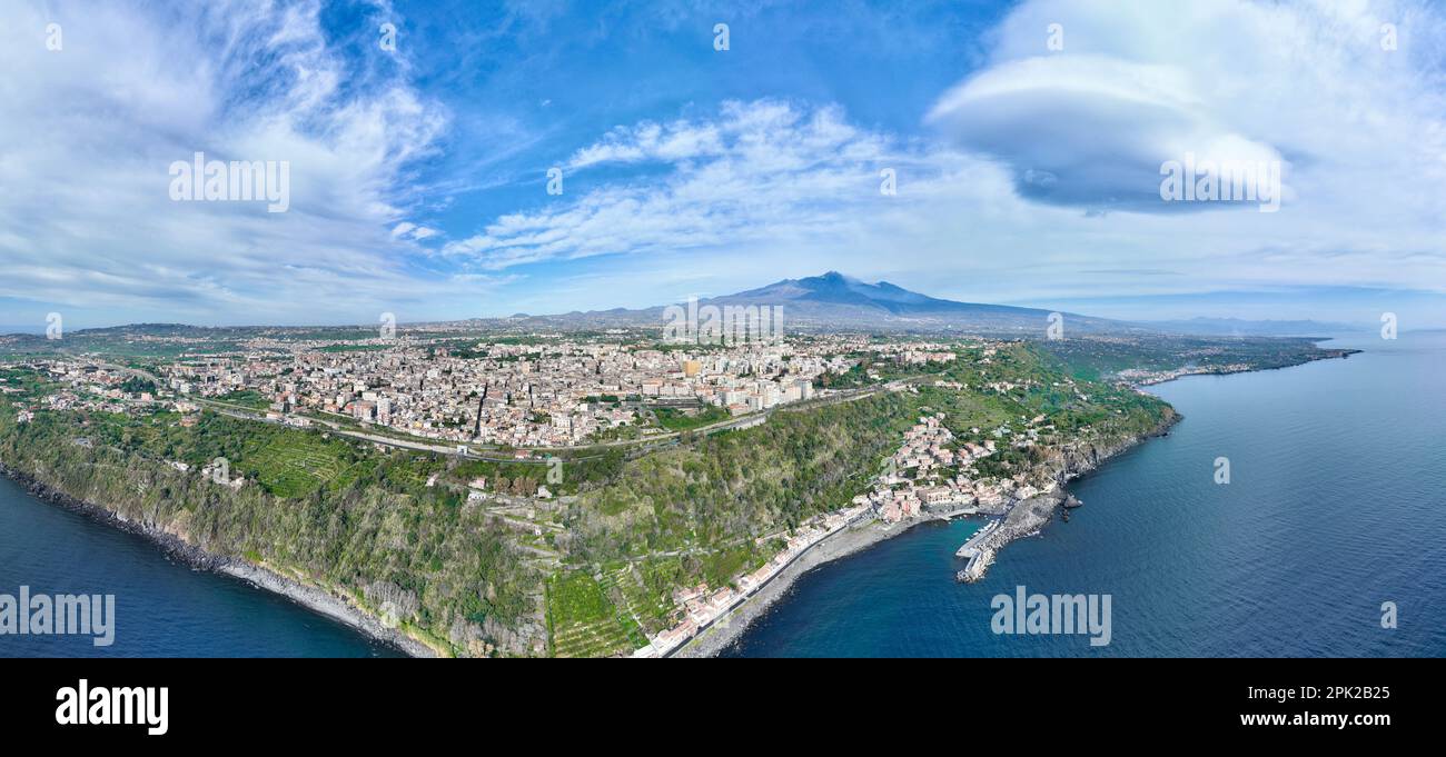 Panoramica aerea dall'alto sulla Timpa di Acireale e Santa Maria la Scala con vulcano Etna con cielo e mare blu Stock Photo