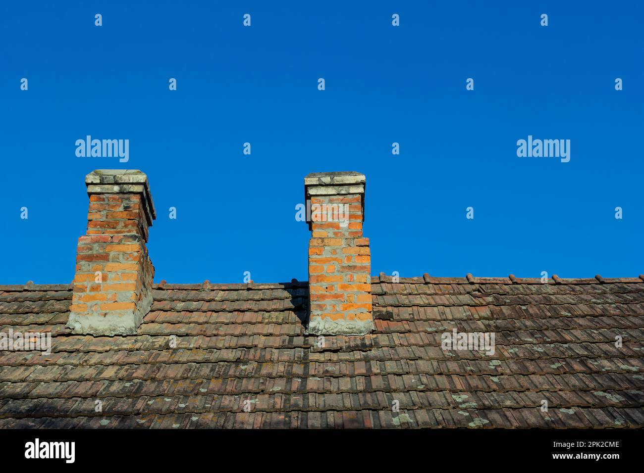red brick chimney in the top of the village house. A roof made of tiles ...