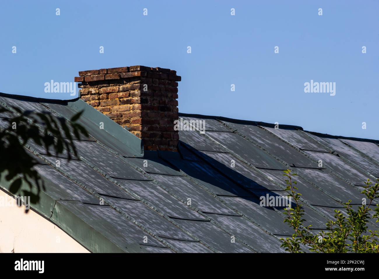 red brick chimney in the top of the village house. A roof made of tiles ...