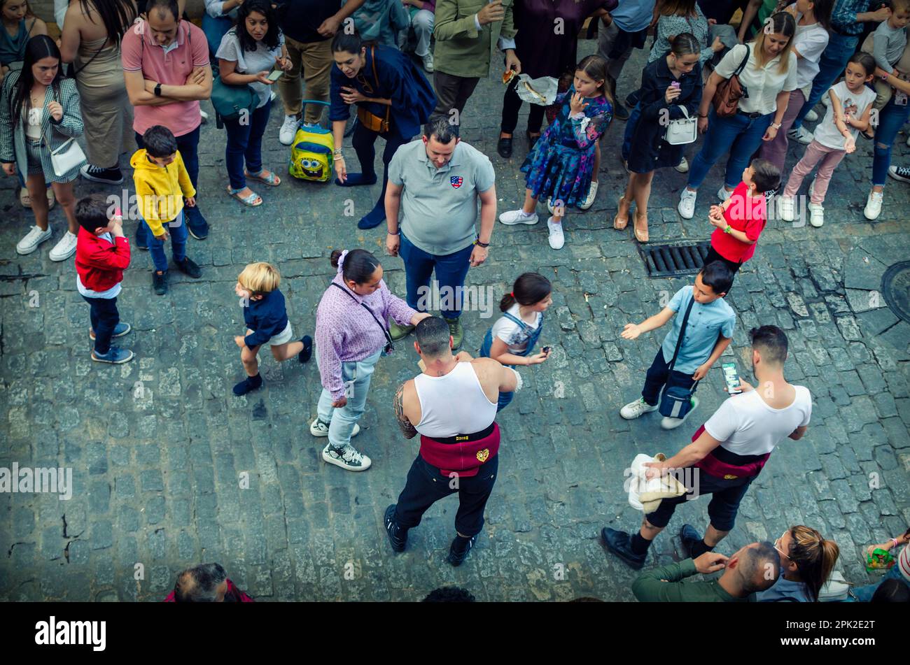 Seville, Spain; April 4, 2023: Float bearer (costalero) of the Cerro brotherhood giving holy cards to kids Stock Photo
