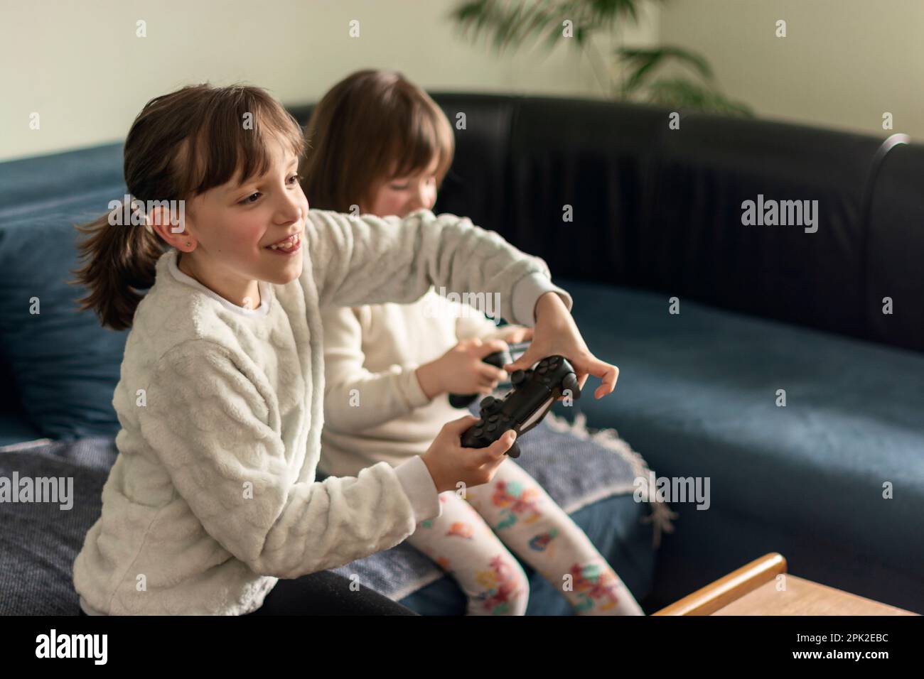 Two happy girls playing video games,PlayStation at home Stock Photo Alamy