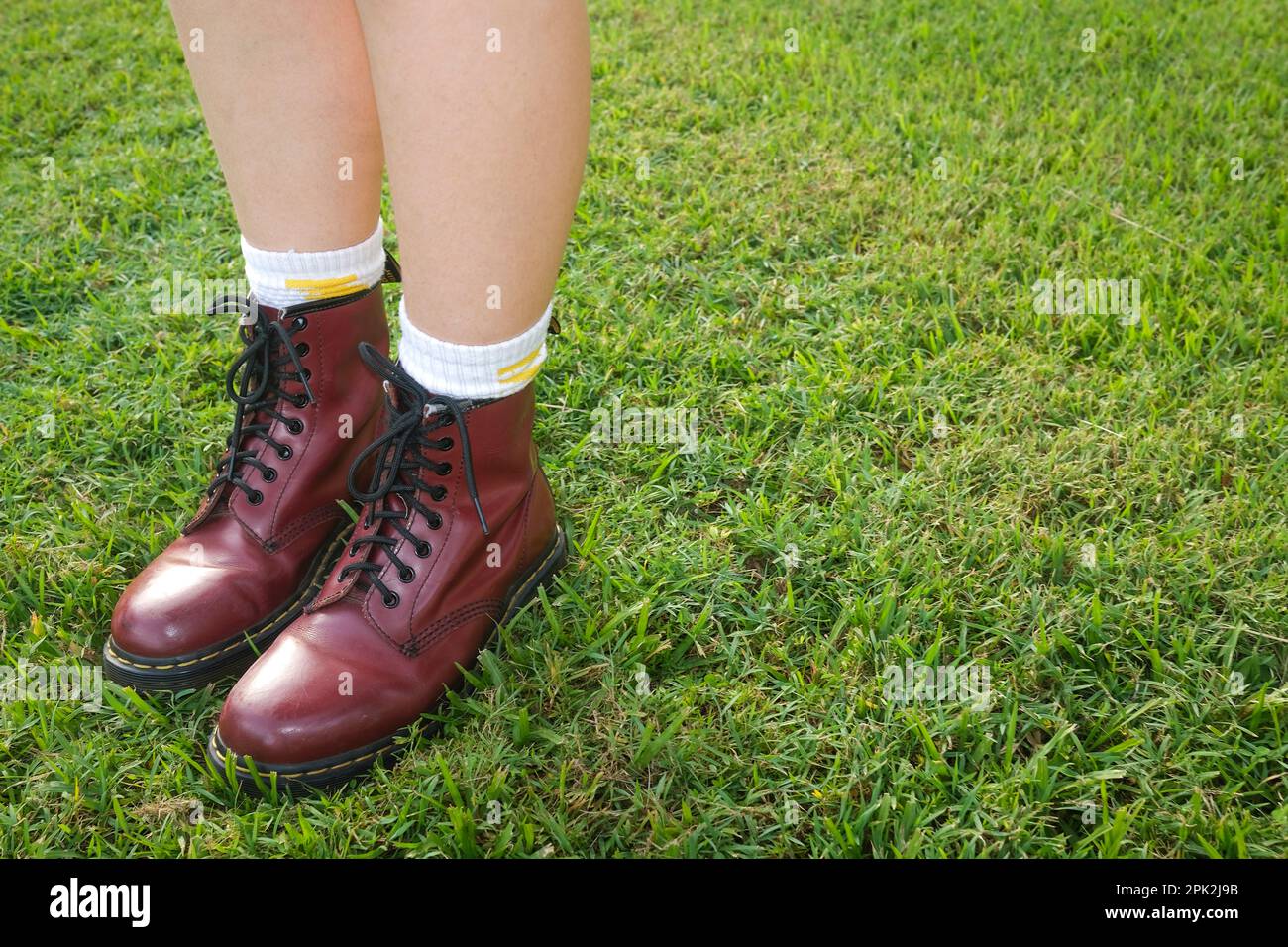 Girls feet in the original Dr. Martens boot cherry red, eight hole, Doc Martens 1460 Stock Photo