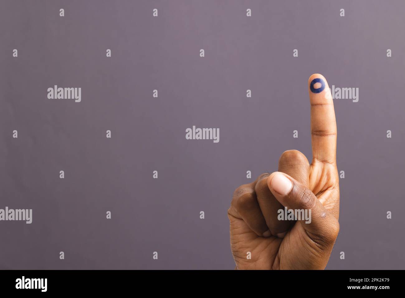 Hand of biracial man with blue ring on outstretched finger, on grey background with copy space Stock Photo