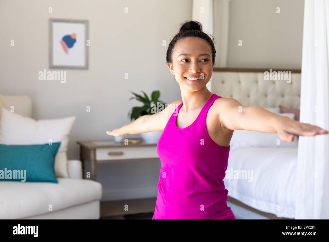 Happy asian woman doing yoga, stretching in bedroom Stock Photo