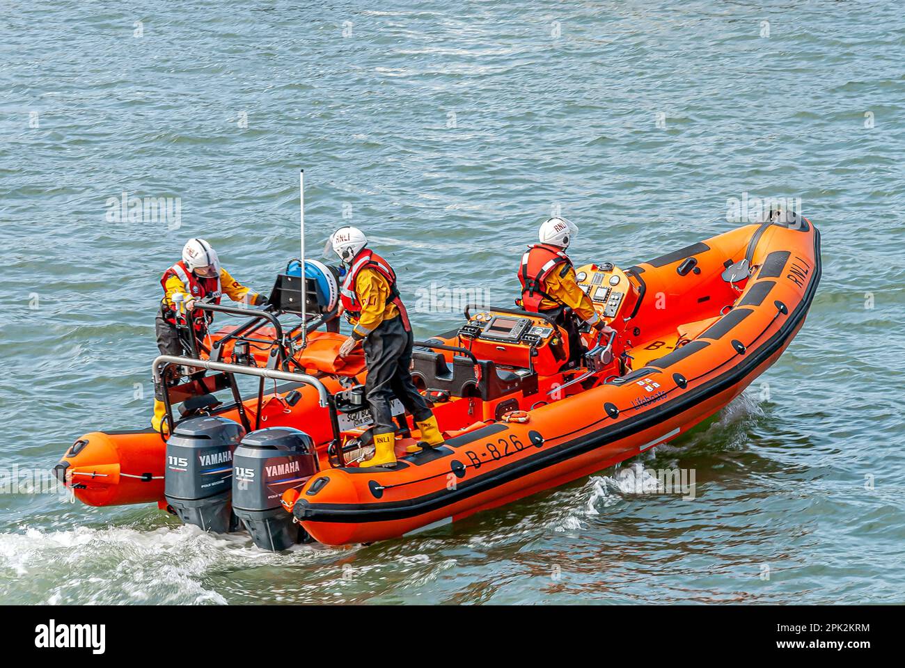 Life boat crew exercising in a dingy at Poole Harbour, Dorset, England