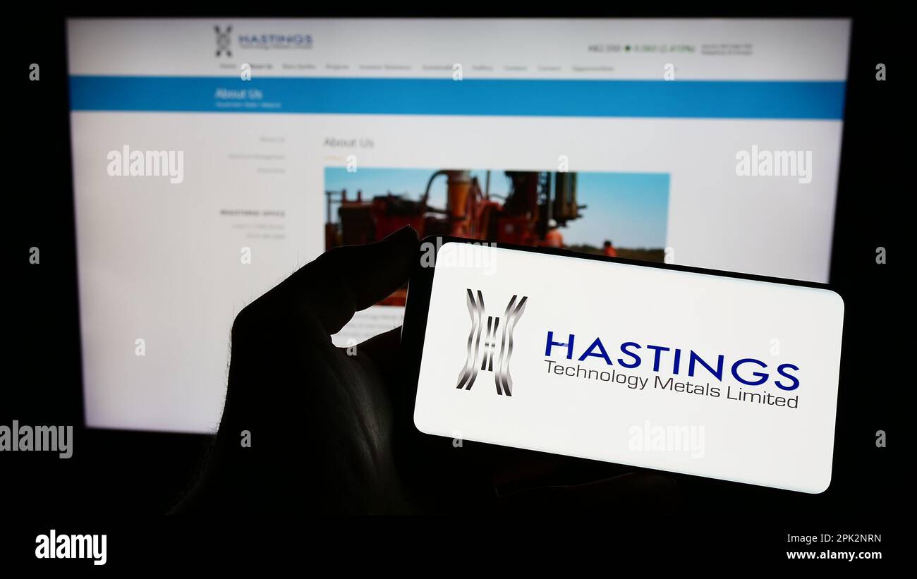 Person holding smartphone with logo of company Hastings Technology