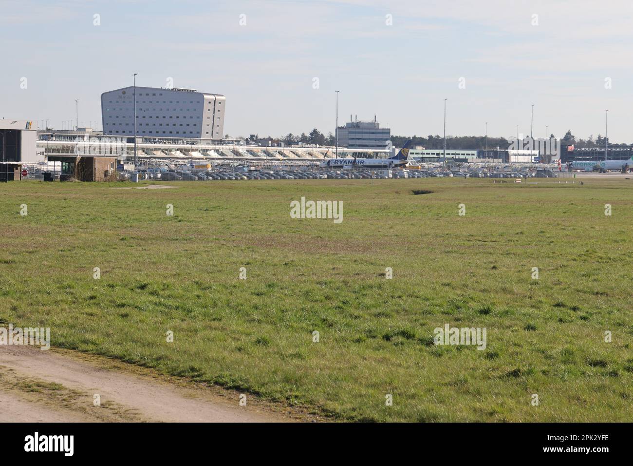 View on Eindhoven Airport  with parked cars and airplanes seen from the airside on a sunny day Stock Photo