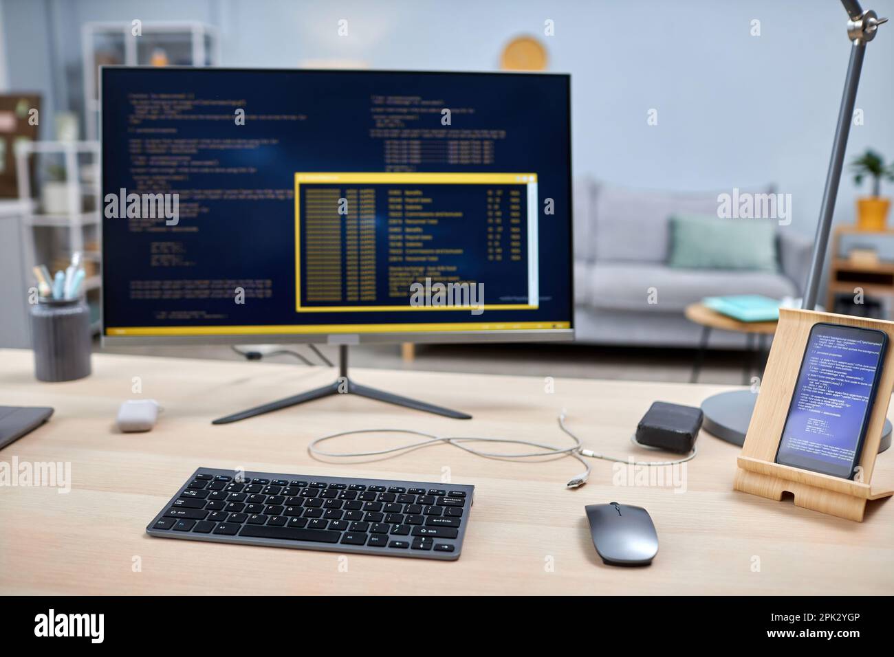 Close up of smartphone with code lines on IT developers workplace, copy space Stock Photo