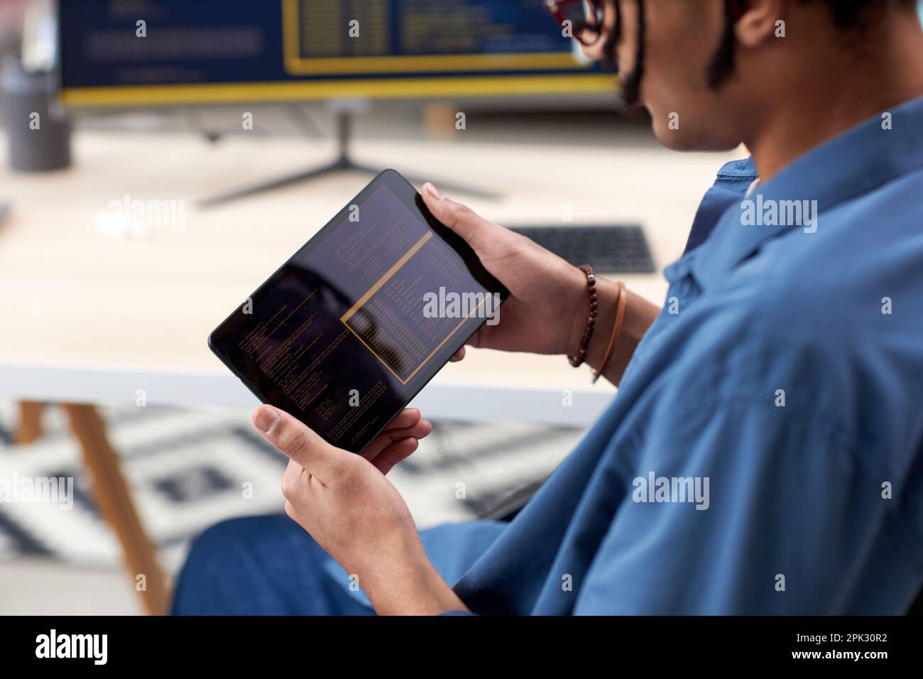Close up of black computer programmer holding tablet and writing code for mobile devices Stock Photo