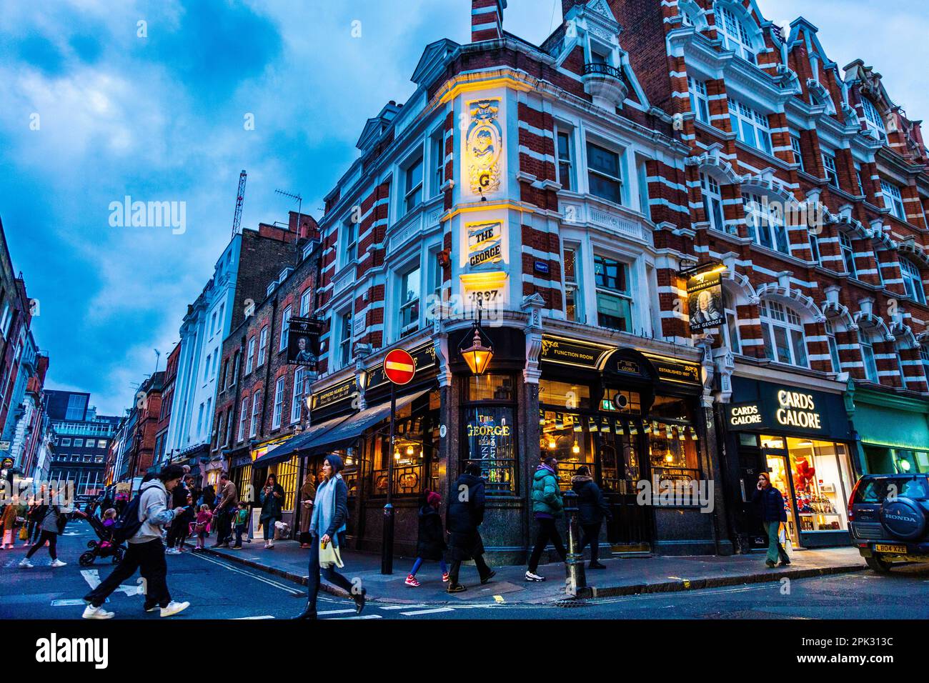 Exterior of Victorian style 18th century pub The George in Soho at night, London, UK Stock Photo