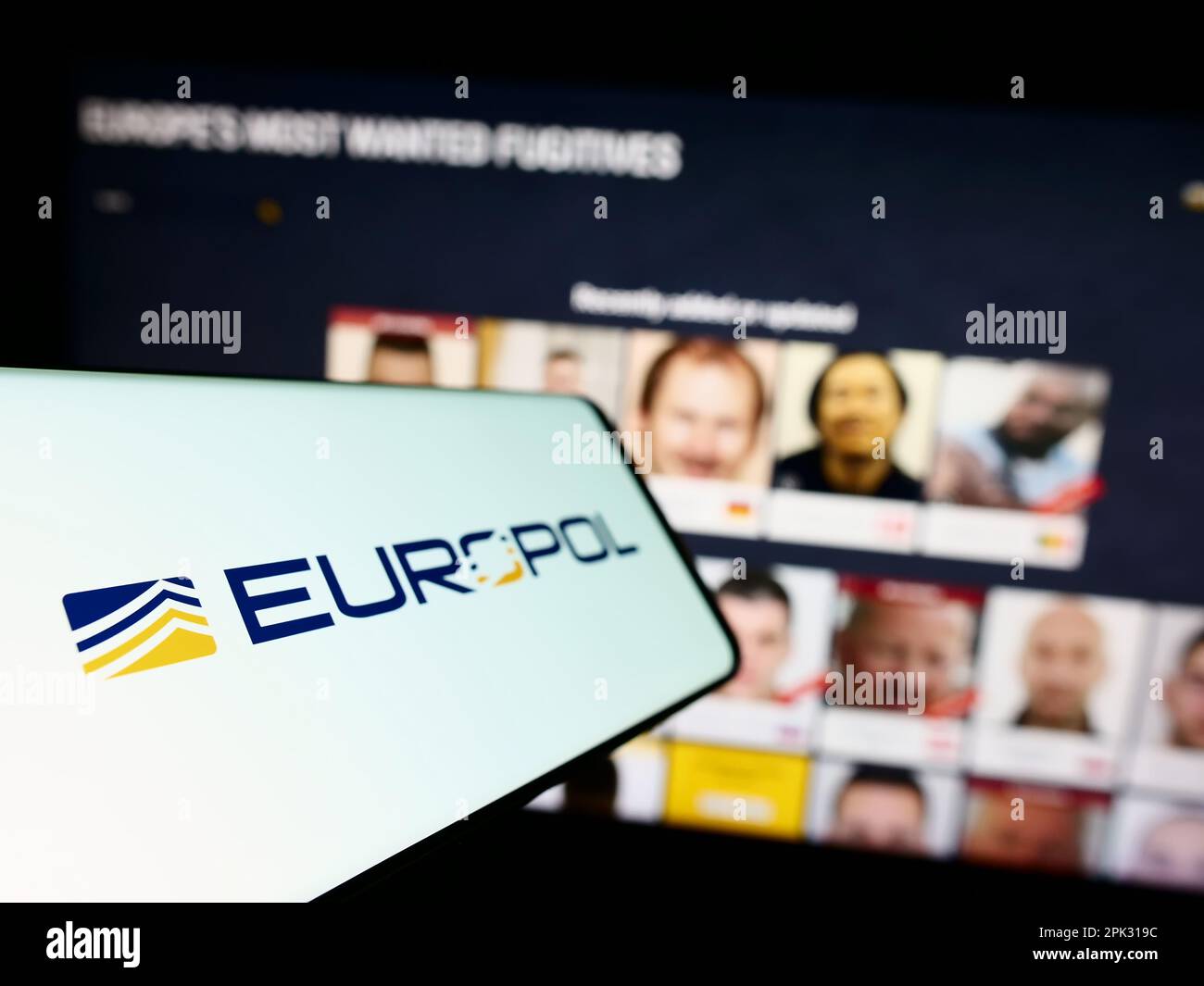 Cellphone with logo of EU law enforcement agency Europol on screen in front of website. Focus on left of phone display. Stock Photo