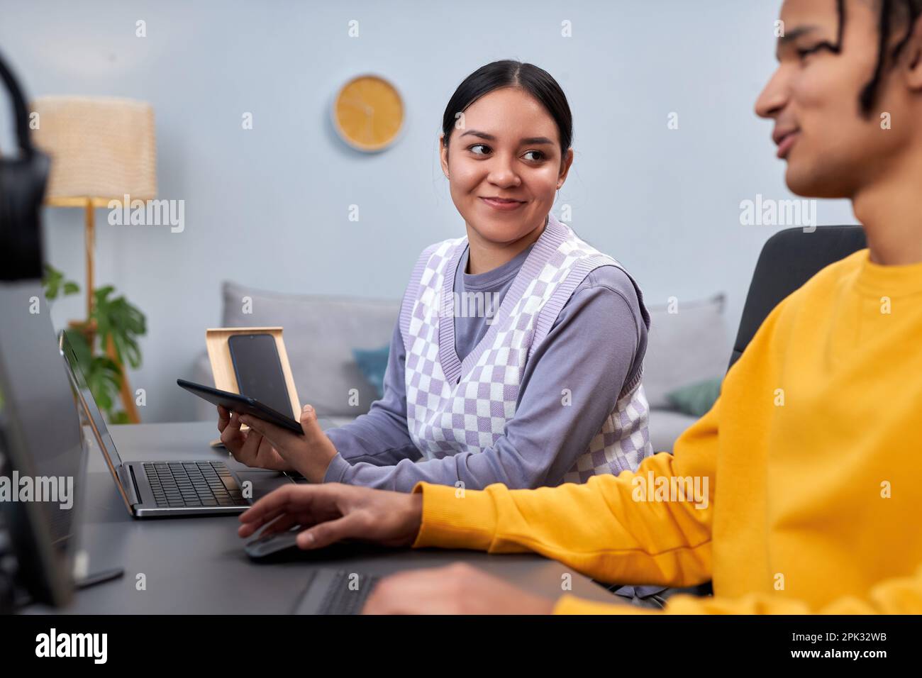Portrait of young woman smiling at male colleague while working on software development project together Stock Photo