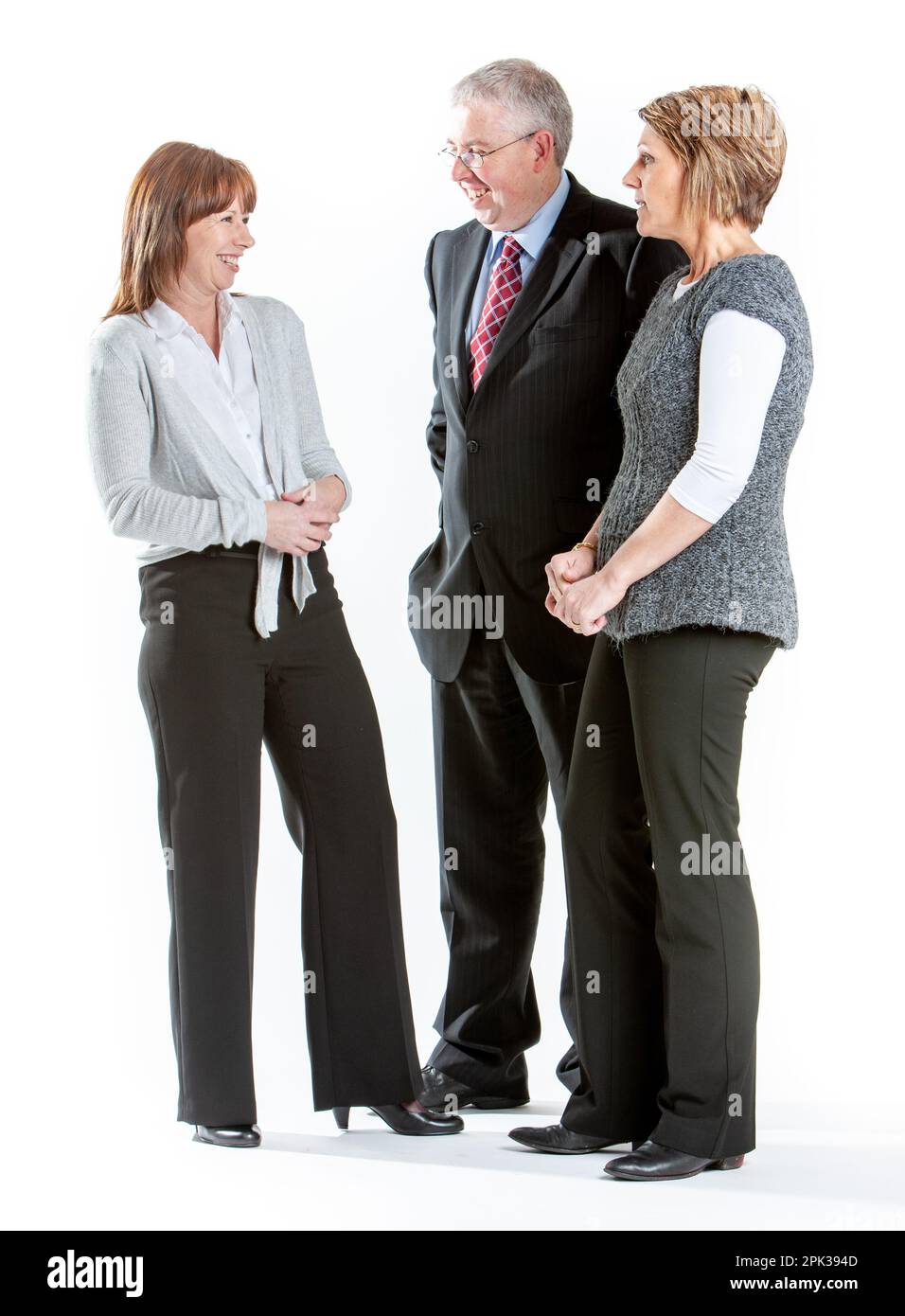 Business Colleagues: Candid Professionals. Full length portrait of a friendly business team isolated on white. From a series of related images. Stock Photo