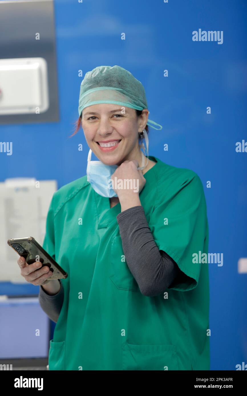 nurse in operating room holding cell phone Stock Photo