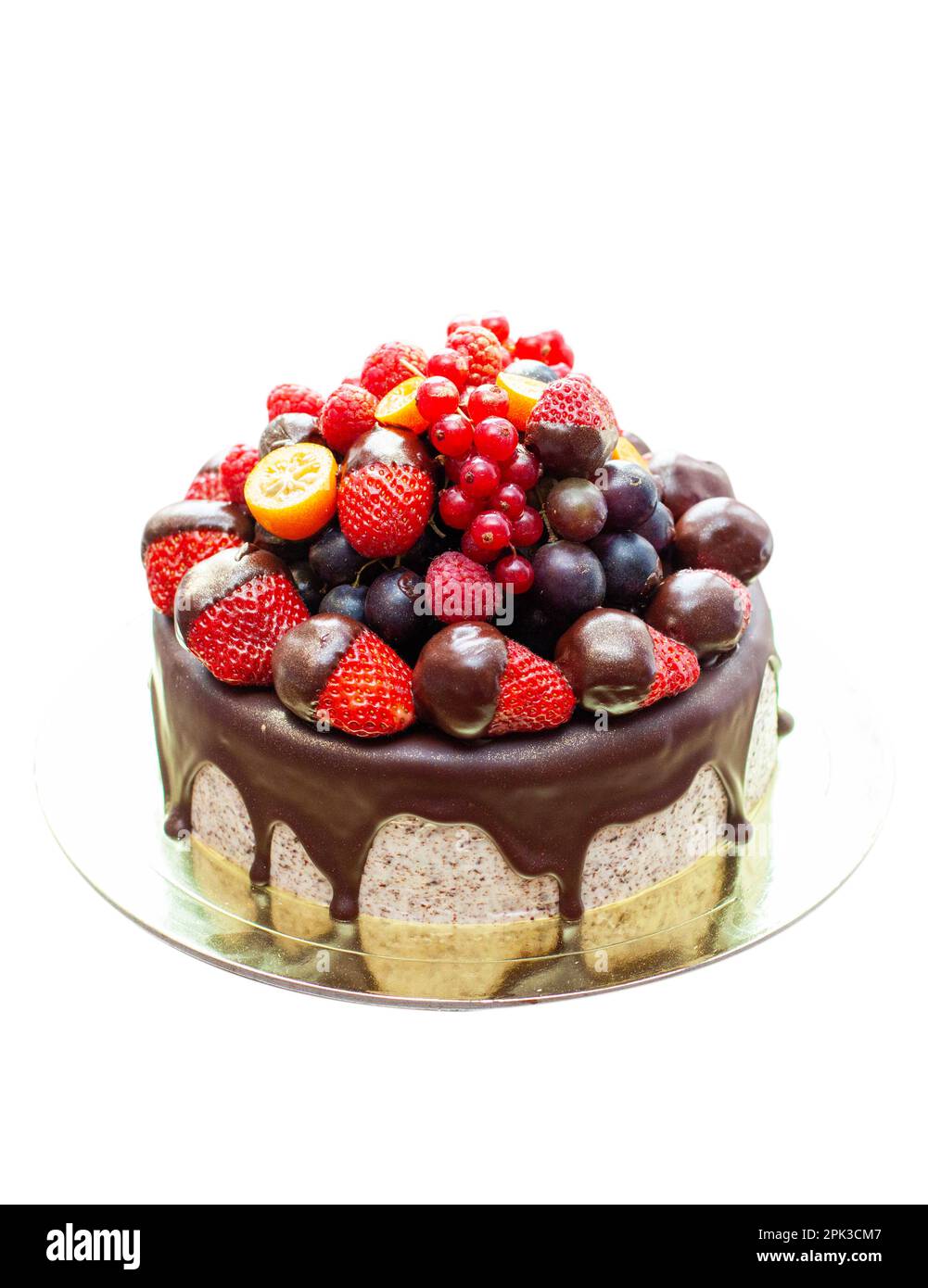 Cake decorated with strawberry dipped into melted chocolate, raspberry, blueberry and red currant. Isolated on plain background Stock Photo