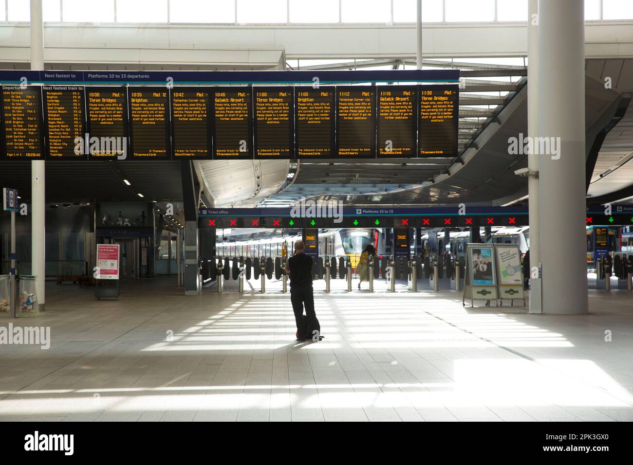 A passenger is silhouetted against a shiny concourse at London Bridge ...