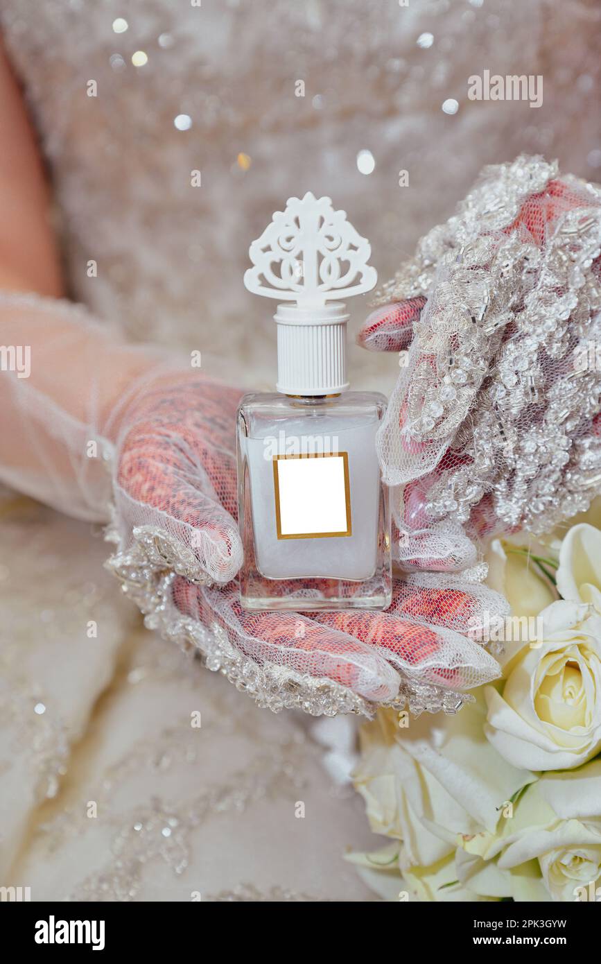 An Arab bride holding a bottle of luxurious perfume Stock Photo