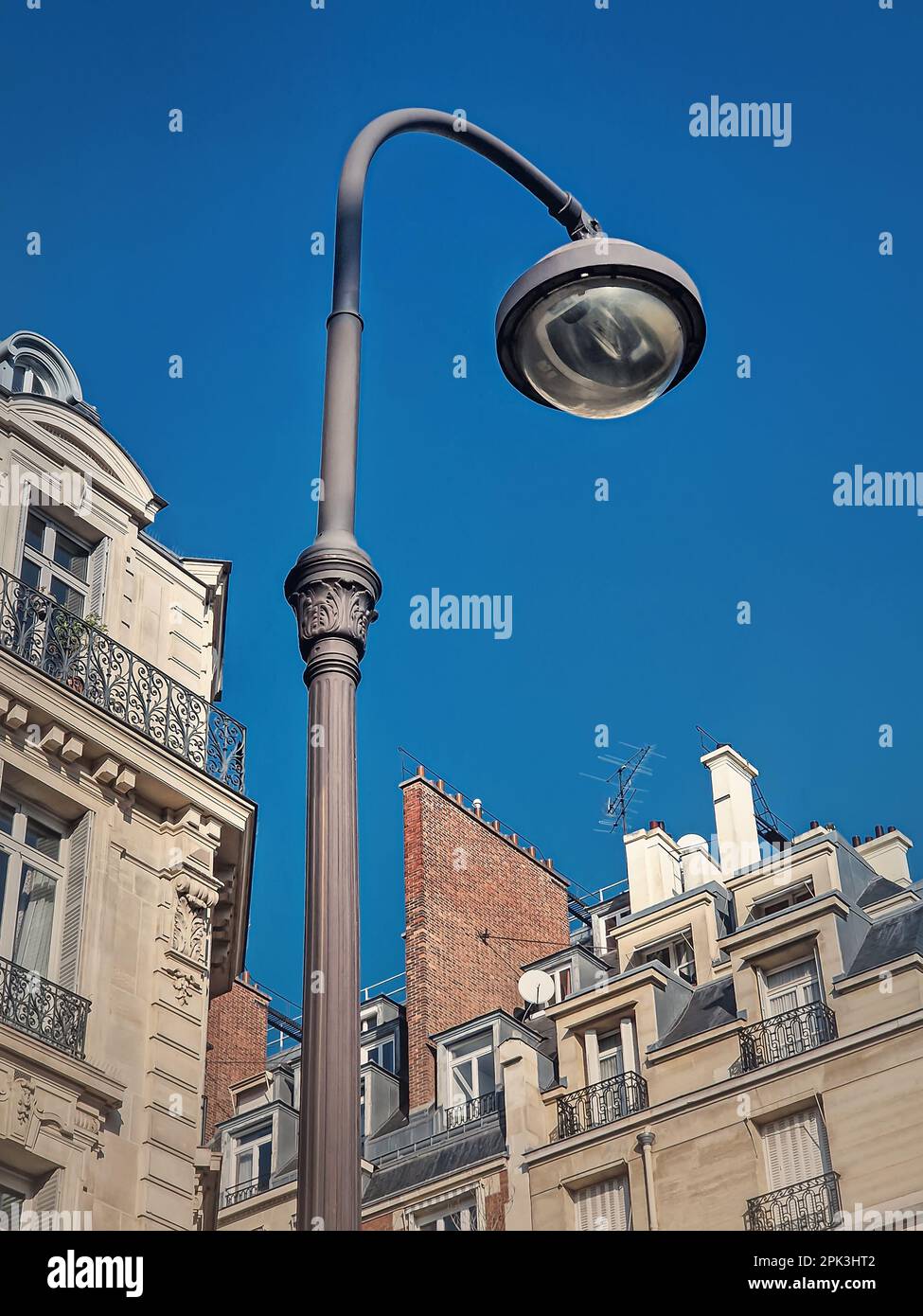 Retro style street lamp in an old Paris district with view to the blue sky background Stock Photo