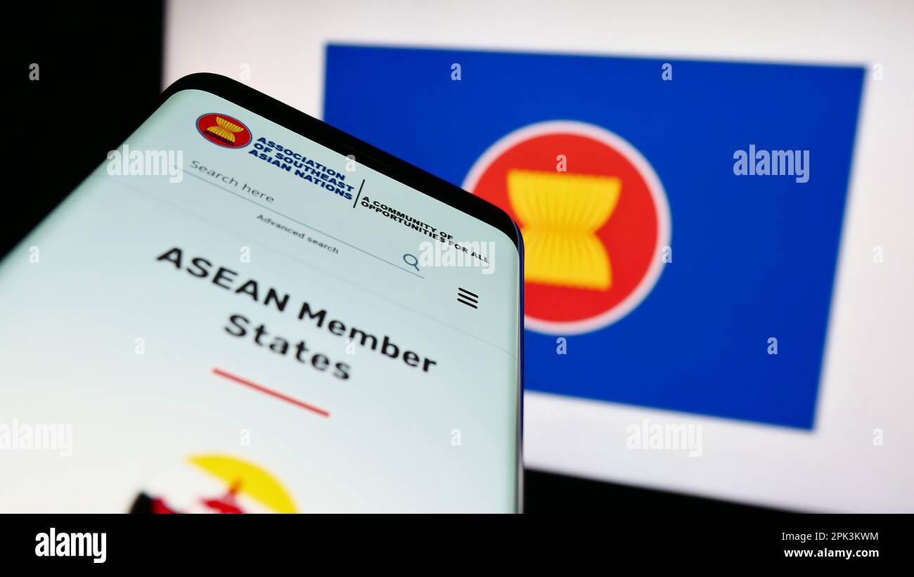 Smartphone with website of Association of Southeast Asian Nations (ASEAN) on screen in front of logo. Focus on top-left of phone display. Stock Photo