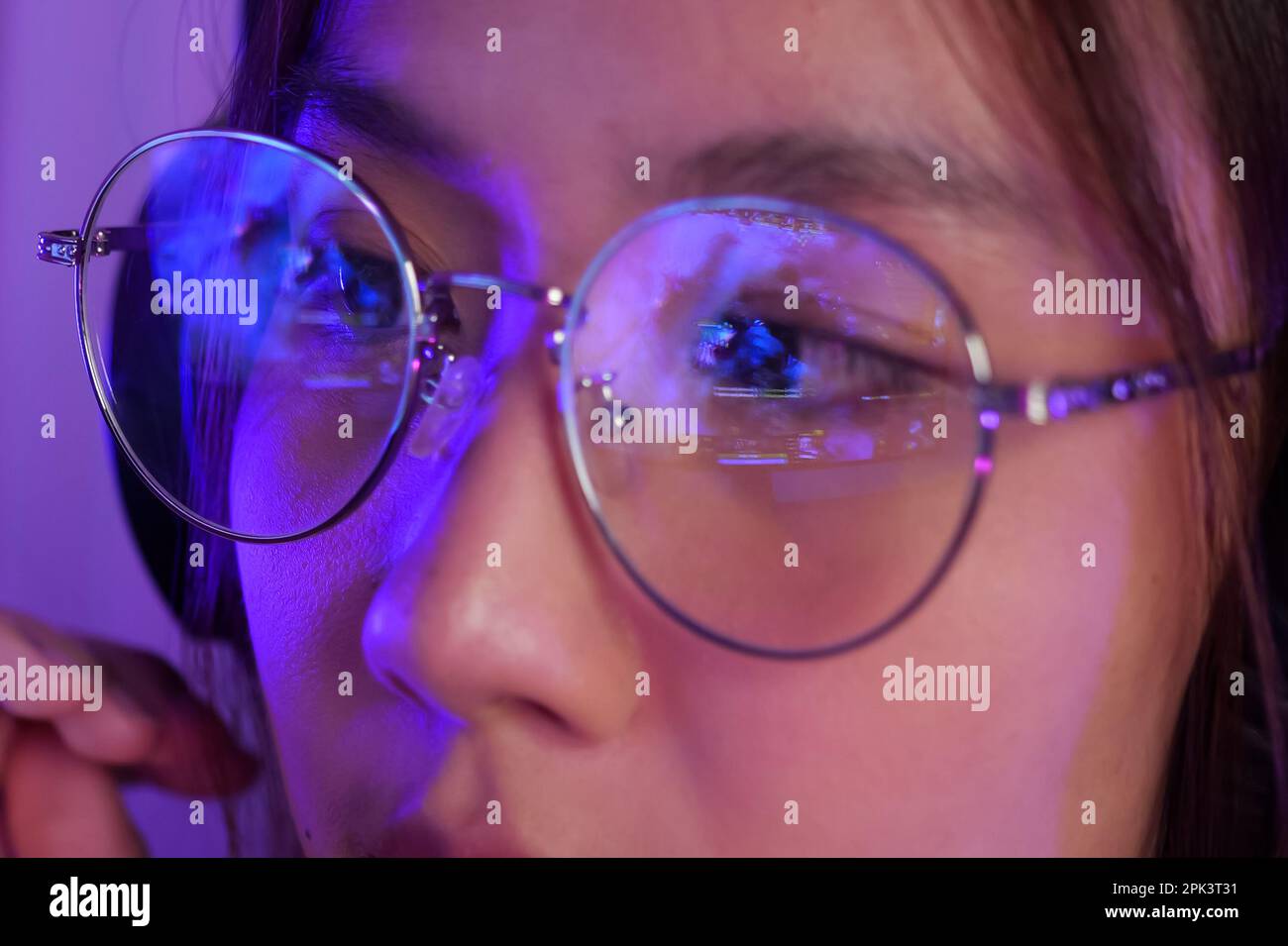 Female gamer wearing glasses for reducing eye strain blurred vision at