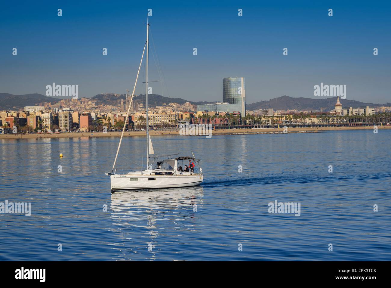 The Marenostrum or Gas Natural tower behind a boat in the sea in Barcelona (Catalonia, Spain) ESP: La torre Marenostrum o de Gas Natural Stock Photo