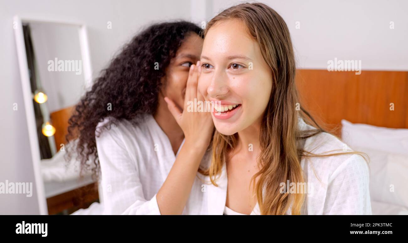 Diverse female close friends sharing secrets, Two women gossiping at