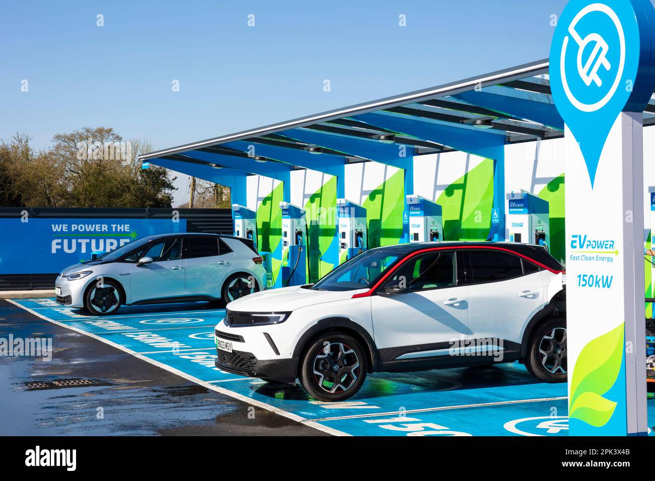 electric cars UK - electric cars charging at public electric car chargers in an MFG EV Power EV charging station UK electric vehicles Stock Photo