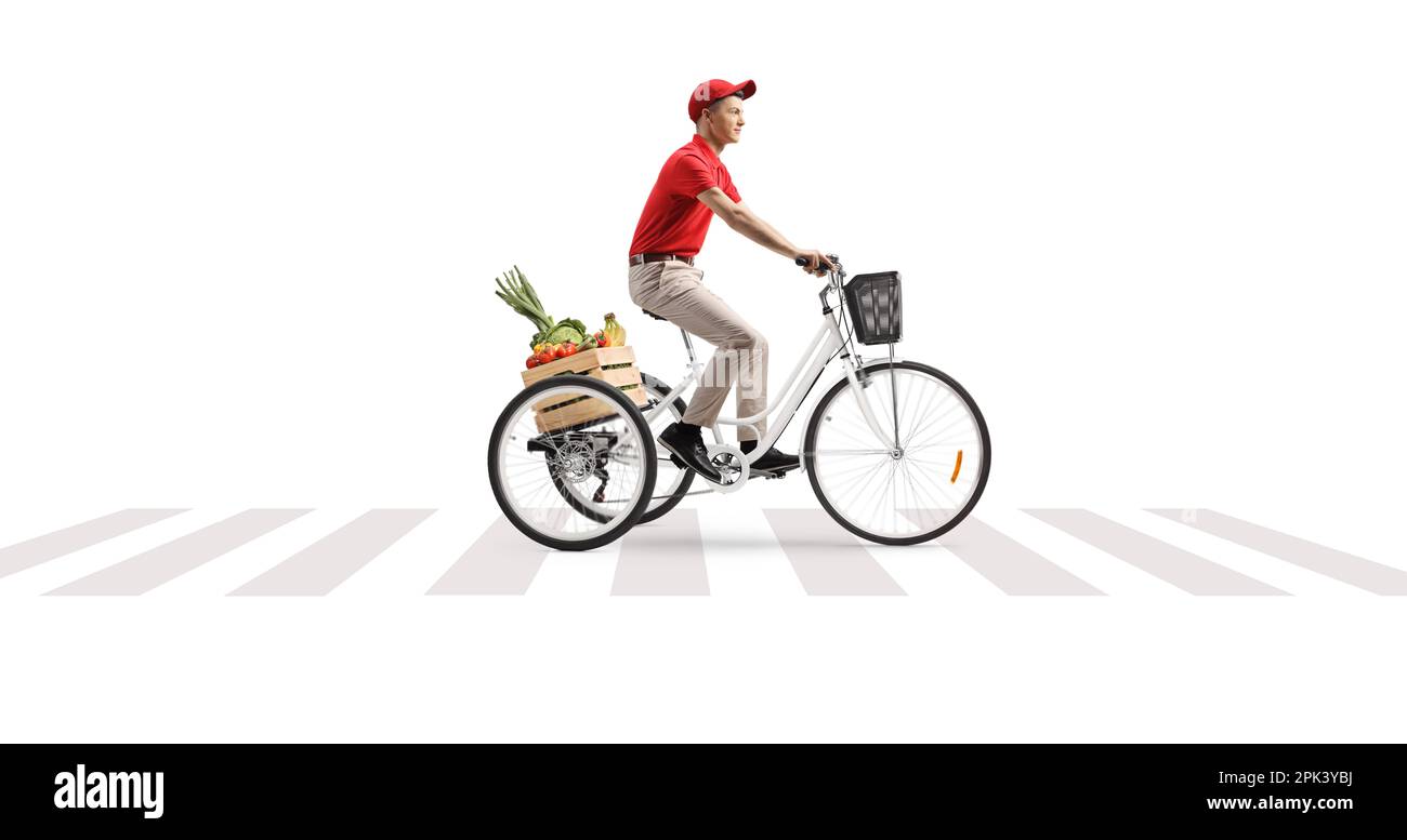 Delivery guy riding a tricycle with a crate of fruits and vegetables at