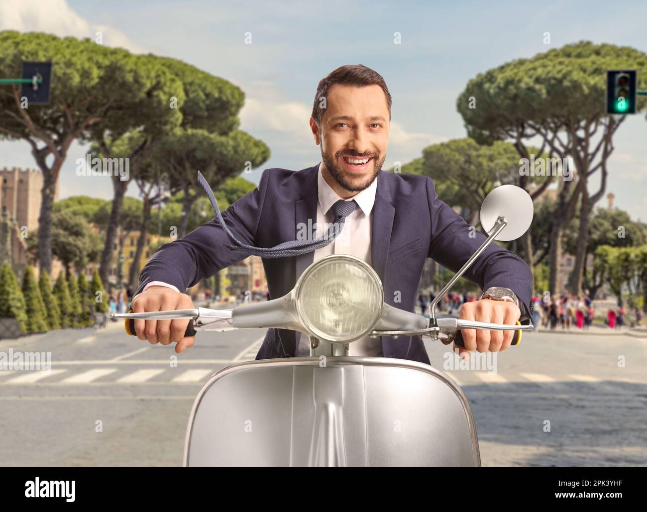 Young man riding a silver scooter on the streets of Rome, Italy Stock Photo