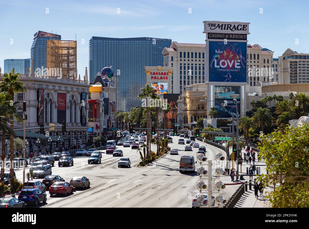 A picture of the Las Vegas Boulevard South with traffic, palm trees and casinos on both sides of it. Stock Photo