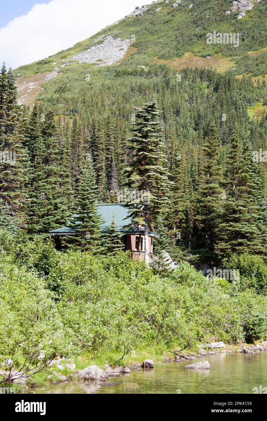 The Summer view of a small wooden cabin 900 meters above sea level by Upper Dewey Lake outside
