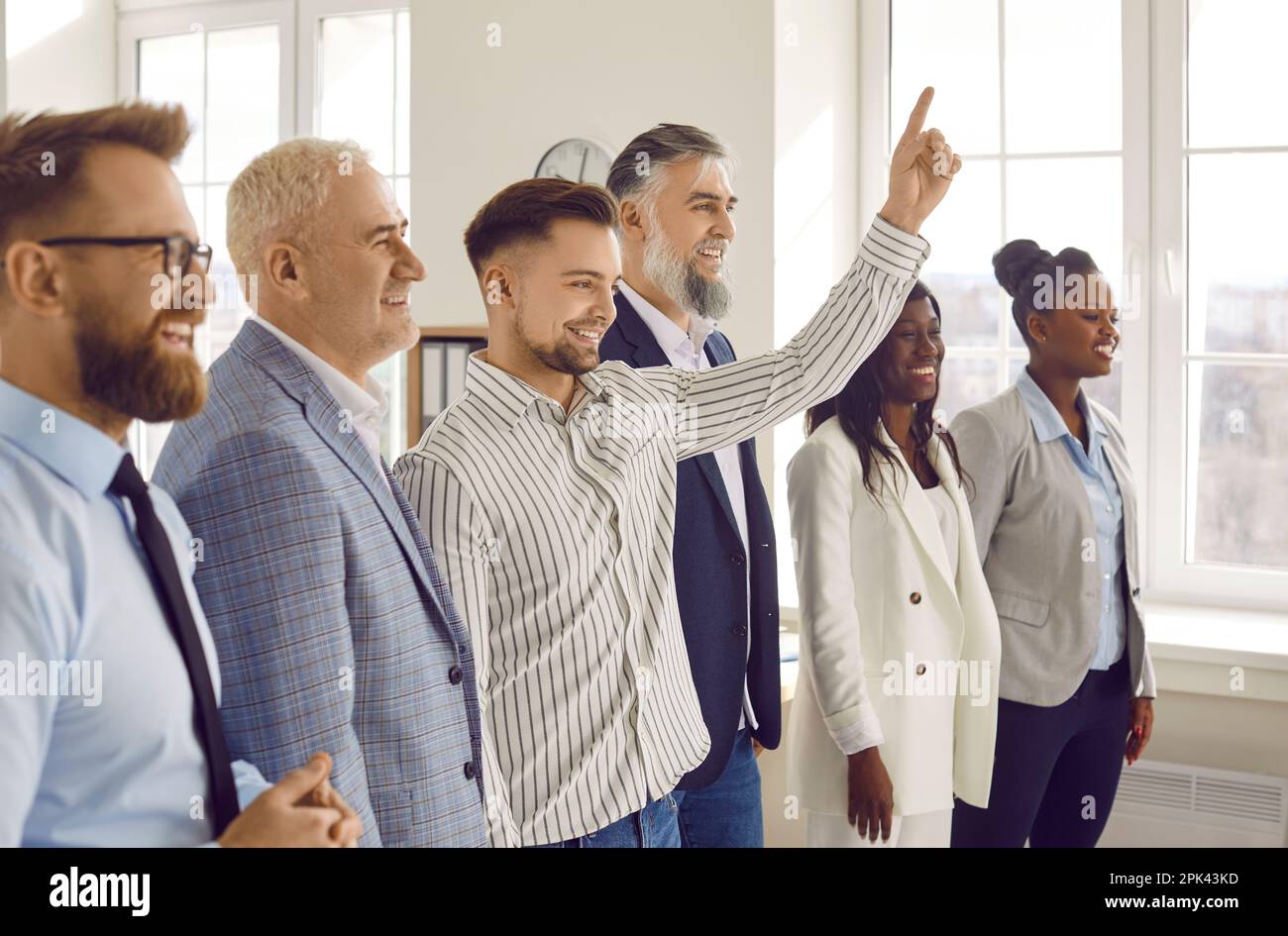 Diverse smiling business people standing together in office Stock Photo ...