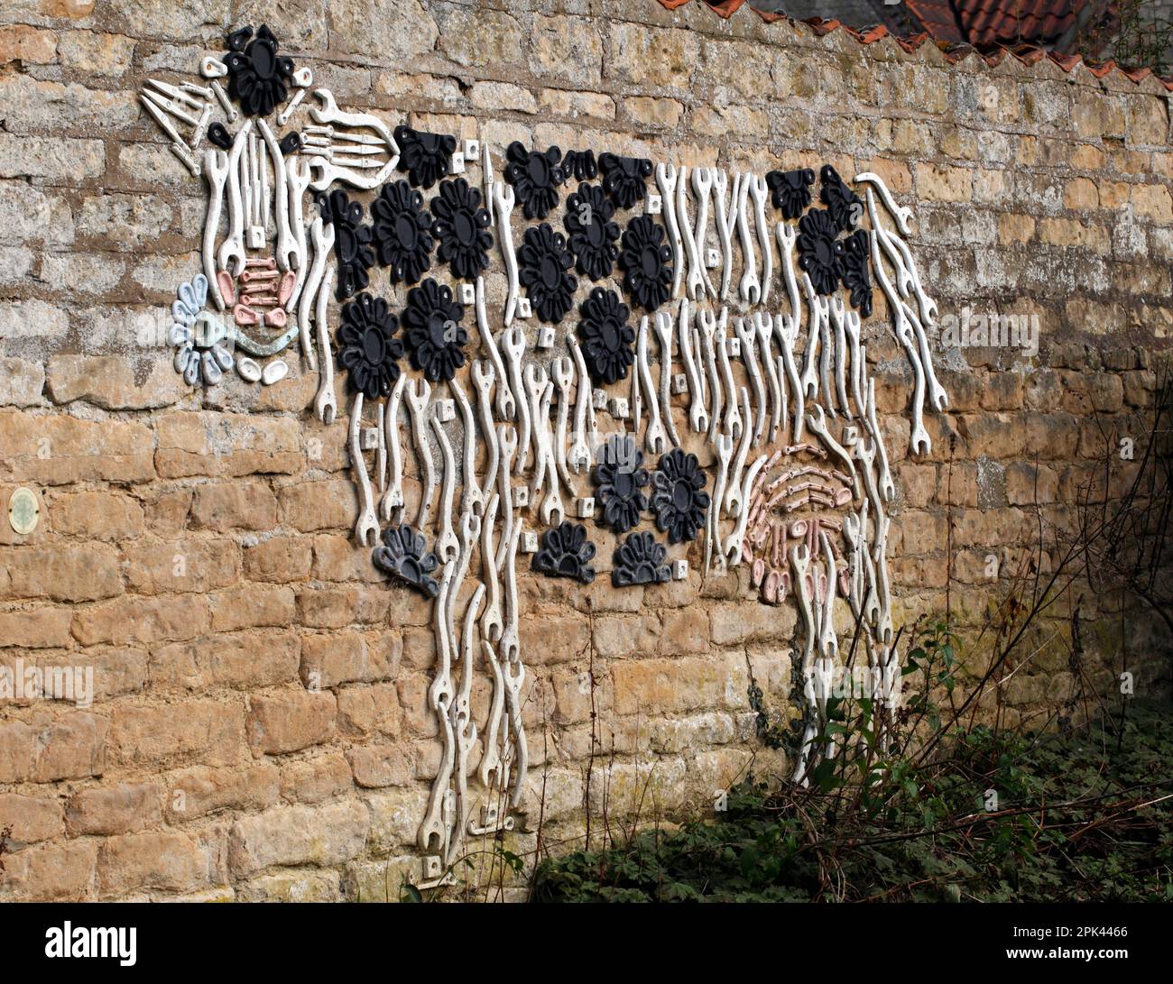 Wall art in Nocton, Lincolnshire. Depiction of a cow, using spanners ...