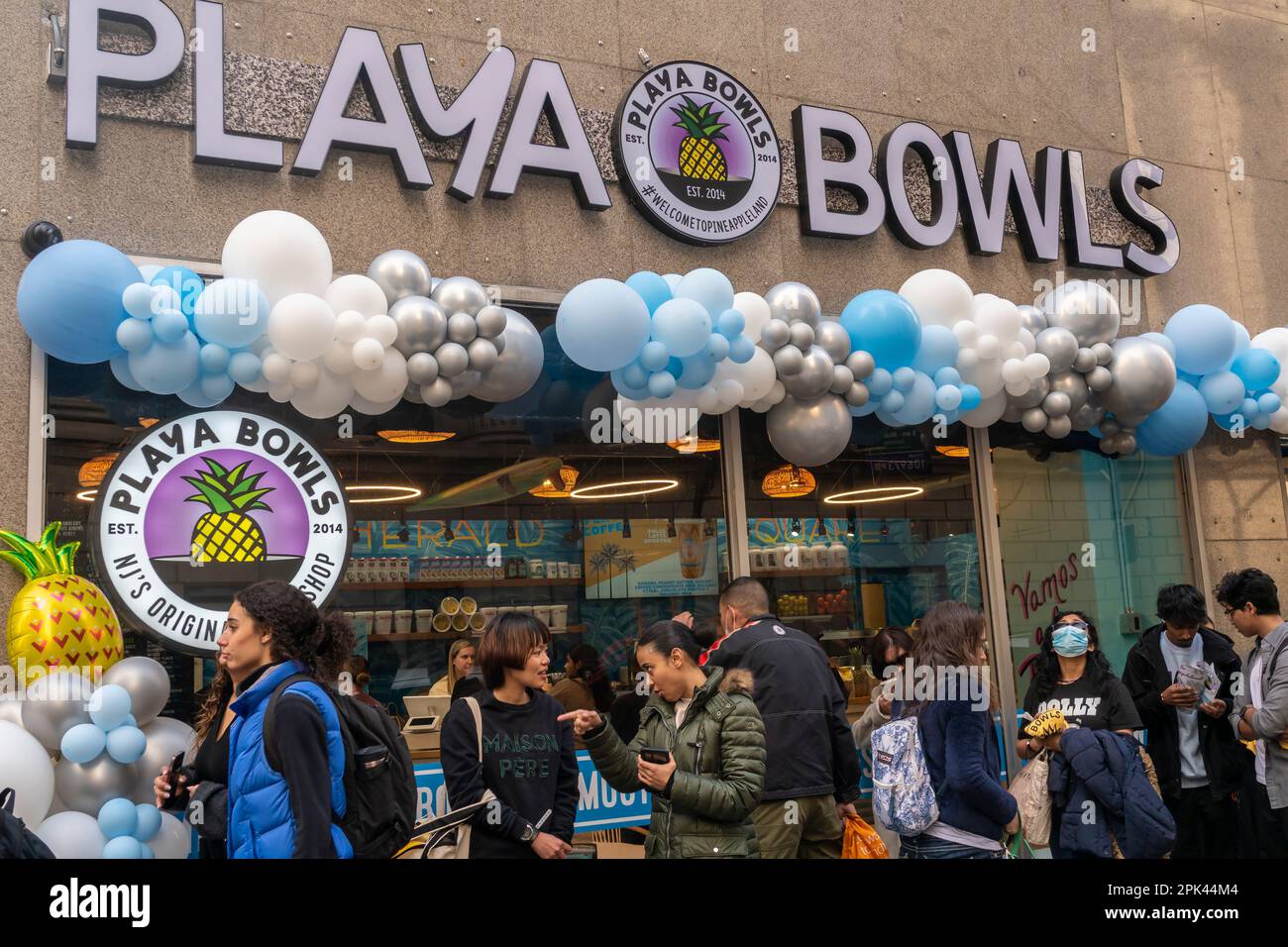 Hundreds of people wait in line for the grand opening of a branch of