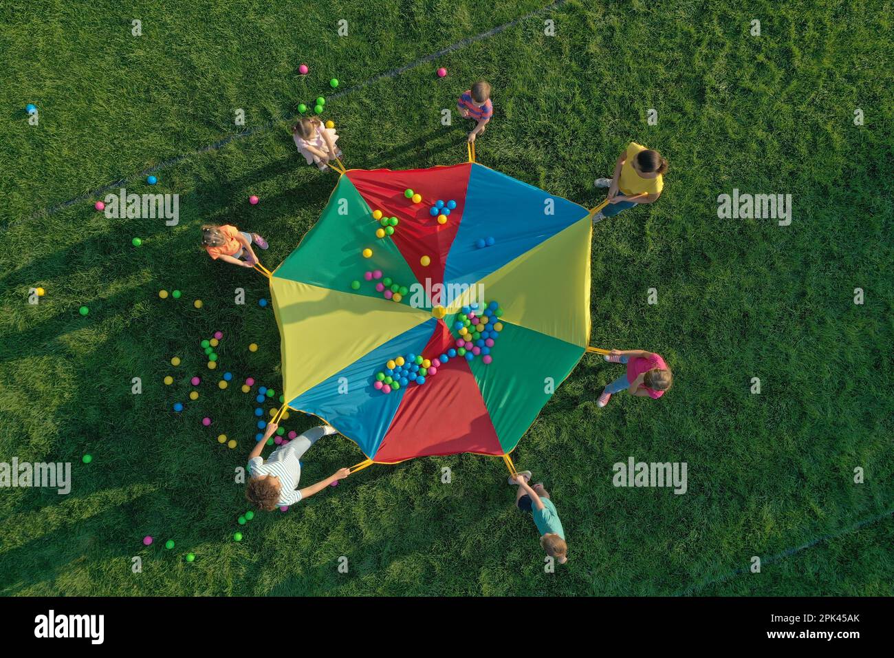 Group of children and teachers playing with rainbow playground